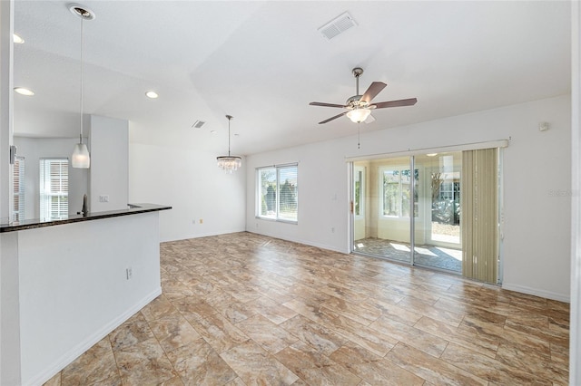 unfurnished living room with visible vents, baseboards, recessed lighting, ceiling fan with notable chandelier, and a sink