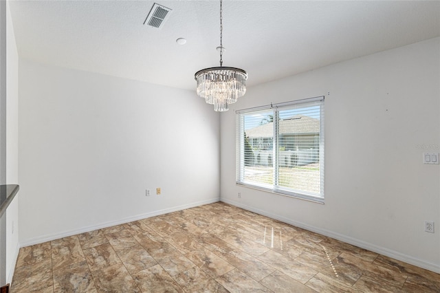 empty room featuring visible vents, baseboards, and a chandelier