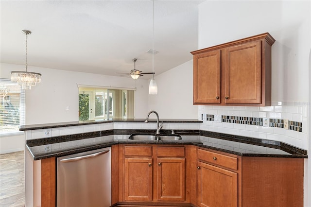 kitchen with dark stone countertops, brown cabinets, a sink, stainless steel dishwasher, and tasteful backsplash