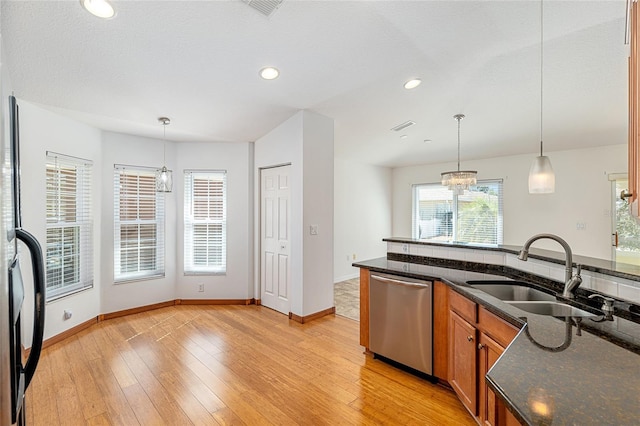 kitchen featuring stainless steel dishwasher, brown cabinetry, light wood-style floors, and a sink