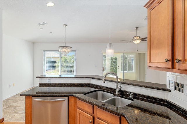 kitchen with visible vents, stainless steel dishwasher, dark stone counters, and a sink