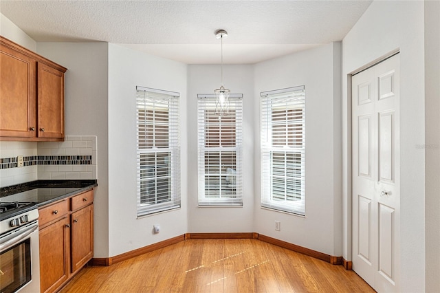 dining space featuring plenty of natural light, baseboards, and light wood-type flooring