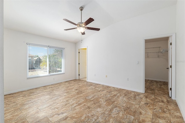 unfurnished bedroom with a ceiling fan, baseboards, vaulted ceiling, a spacious closet, and a closet