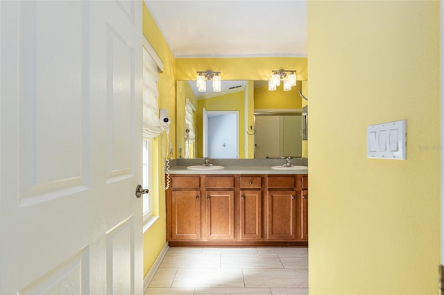 full bathroom featuring double vanity, a stall shower, tile patterned floors, and a sink