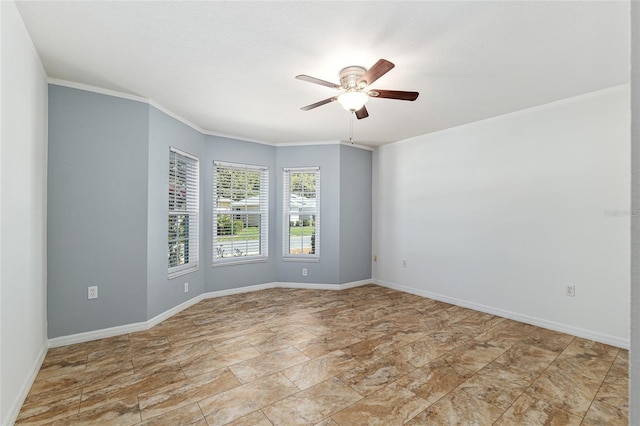 spare room featuring crown molding, baseboards, and ceiling fan