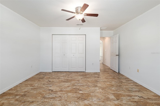 unfurnished bedroom featuring arched walkways, visible vents, baseboards, and a closet