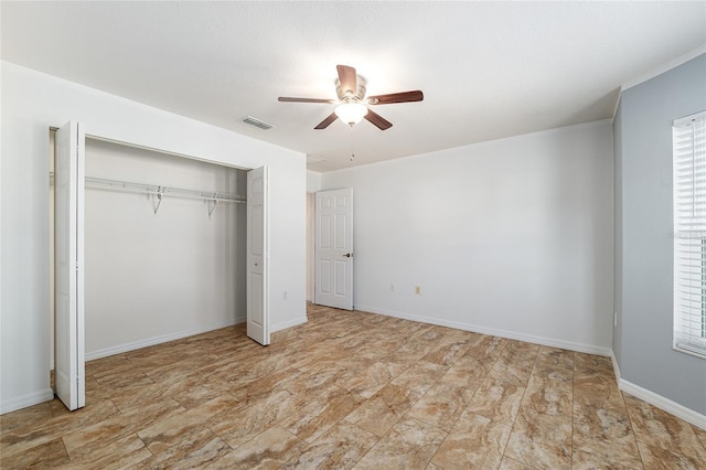 unfurnished bedroom featuring multiple windows, visible vents, a closet, and baseboards