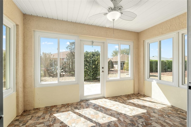 unfurnished sunroom featuring ceiling fan