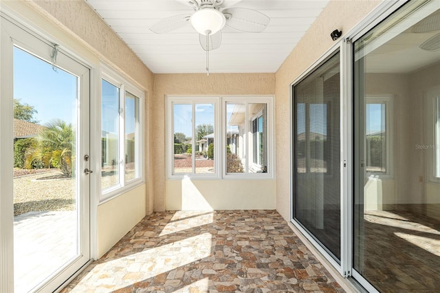 unfurnished sunroom with a ceiling fan