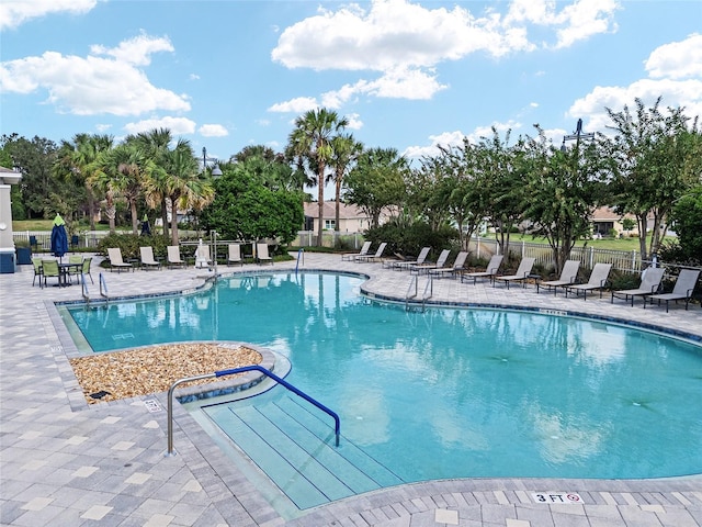 community pool featuring a patio area and fence