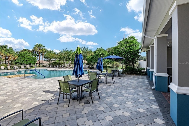 view of patio featuring a community pool and fence