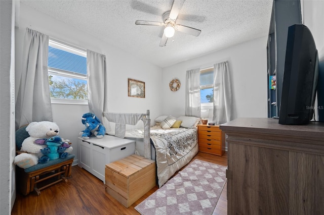 bedroom featuring a ceiling fan, wood finished floors, and a textured ceiling