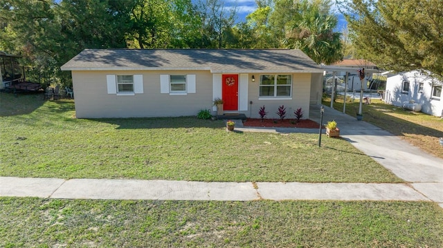 ranch-style home featuring a front yard, concrete driveway, and a carport