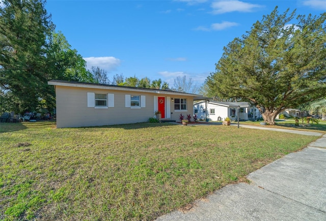 single story home with concrete driveway and a front yard