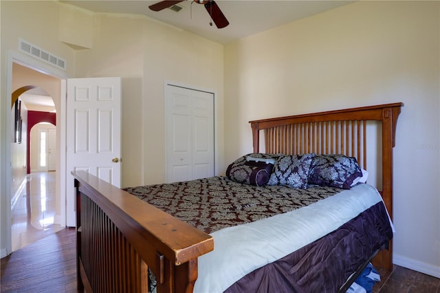 bedroom with wood finished floors, arched walkways, and visible vents