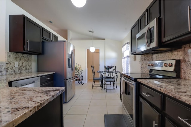 kitchen featuring backsplash, decorative light fixtures, vaulted ceiling, light tile patterned floors, and stainless steel appliances