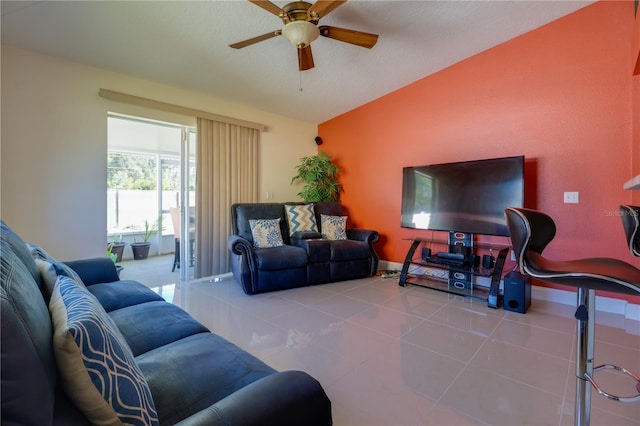 tiled living area featuring lofted ceiling, baseboards, and ceiling fan