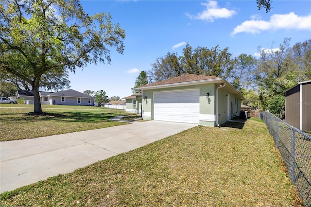 exterior space featuring fence, driveway, stucco siding, a garage, and a lawn