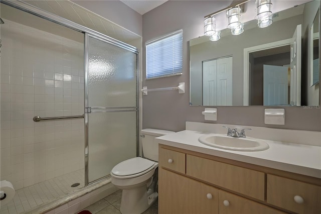 bathroom featuring tile patterned flooring, a shower stall, toilet, and vanity