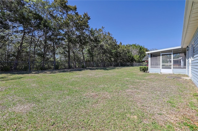 view of yard featuring fence and a sunroom