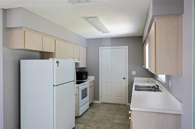 kitchen with white appliances, light brown cabinets, a sink, light countertops, and under cabinet range hood