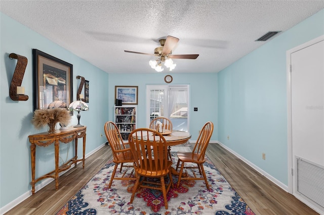 dining space featuring wood finished floors, visible vents, and baseboards