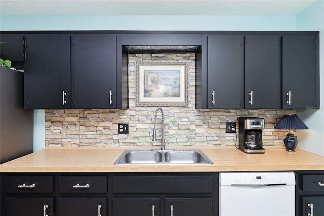 kitchen with tasteful backsplash, a sink, light countertops, and white dishwasher