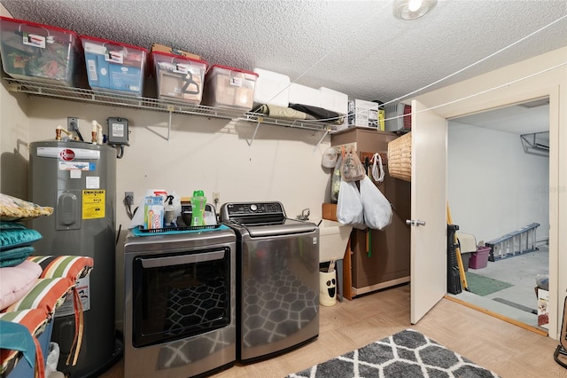 clothes washing area with washing machine and clothes dryer, water heater, laundry area, a textured ceiling, and a sink