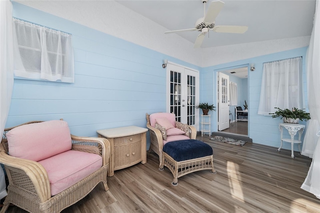 sitting room featuring ceiling fan, french doors, wood finished floors, and vaulted ceiling