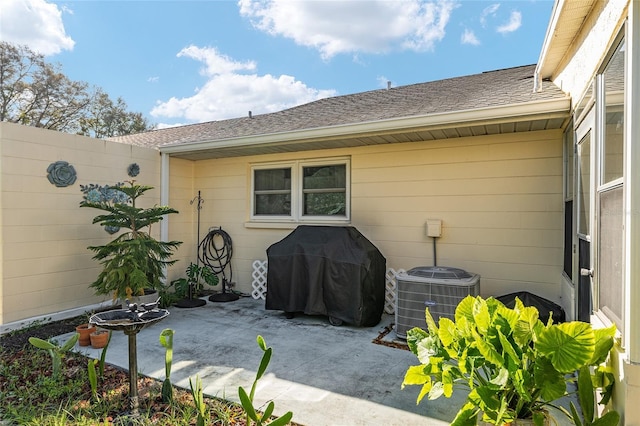 view of patio featuring central AC, a grill, and fence