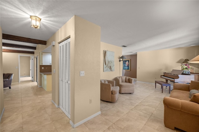 corridor featuring light tile patterned floors, baseboards, beam ceiling, and visible vents