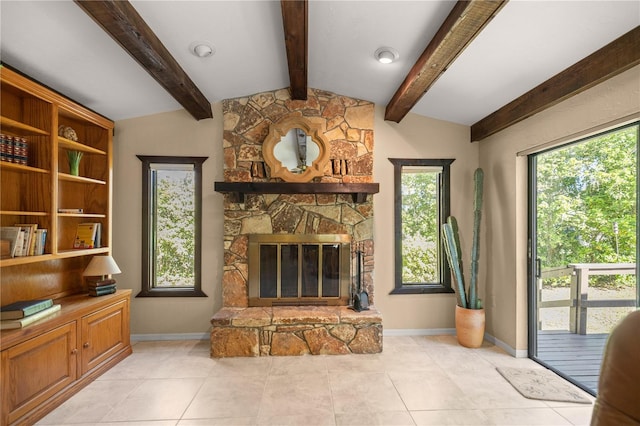 living room featuring lofted ceiling with beams, baseboards, a healthy amount of sunlight, and a fireplace