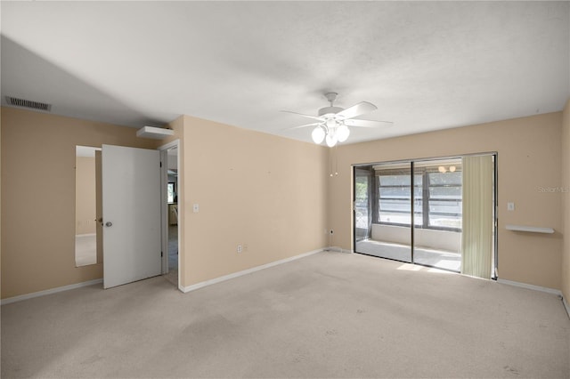 carpeted spare room with visible vents, a ceiling fan, and baseboards