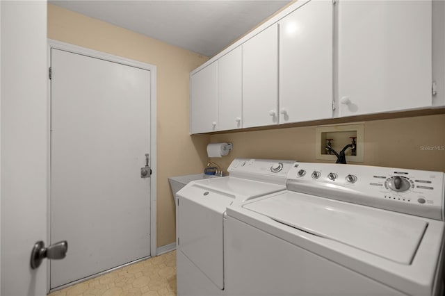 clothes washing area with cabinet space, washing machine and dryer, and a sink