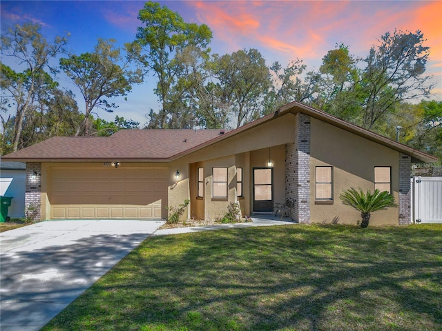 mid-century inspired home featuring stucco siding, a garage, concrete driveway, and a front yard