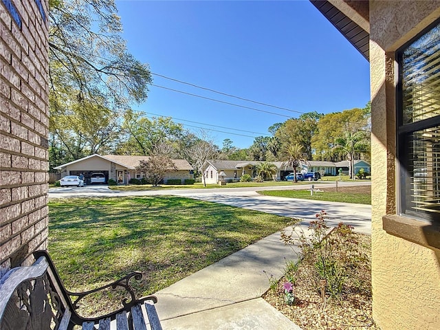 view of yard with a residential view and driveway