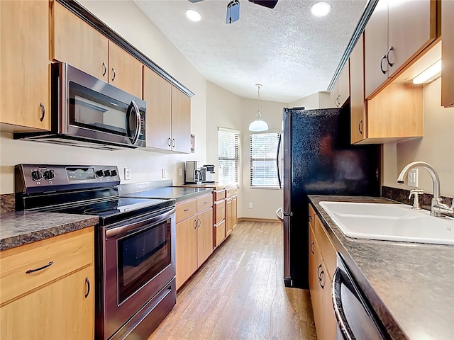 kitchen featuring light brown cabinets, stainless steel electric range, a textured ceiling, and a sink