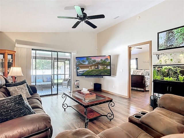 living room featuring wood finished floors, baseboards, visible vents, lofted ceiling, and ceiling fan