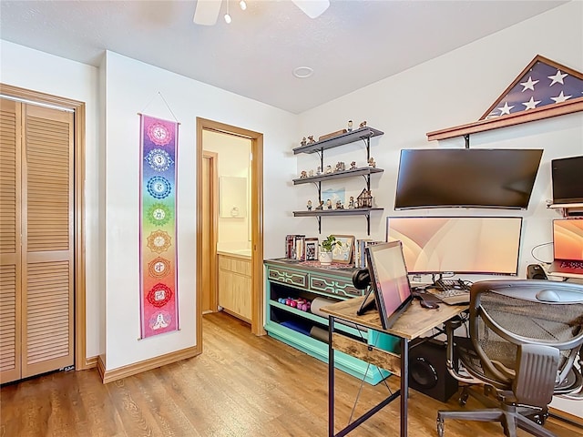 miscellaneous room featuring baseboards, light wood-type flooring, and a ceiling fan