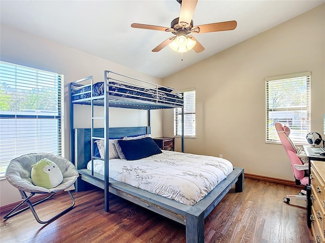 bedroom with multiple windows, lofted ceiling, baseboards, and wood finished floors