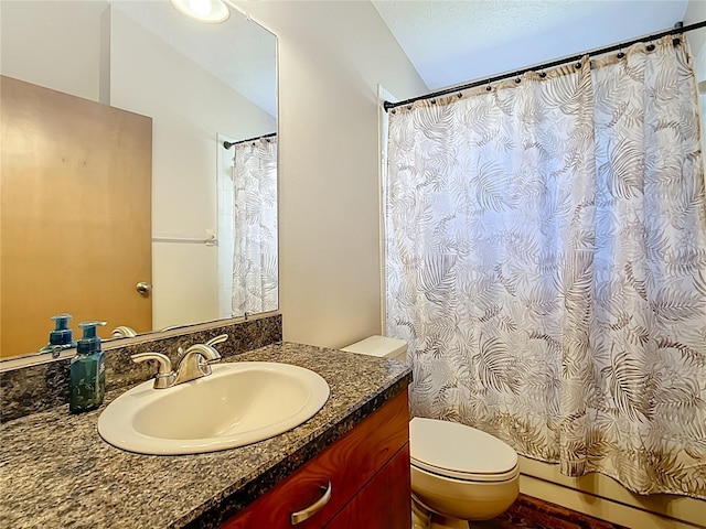 bathroom featuring curtained shower, toilet, vanity, and vaulted ceiling