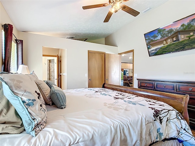 bedroom featuring visible vents, ensuite bath, a ceiling fan, and vaulted ceiling