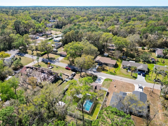 bird's eye view with a wooded view