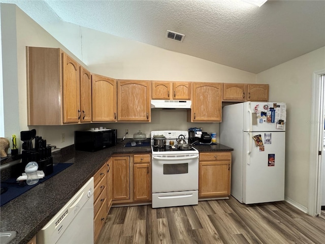 kitchen featuring white appliances, wood finished floors, visible vents, vaulted ceiling, and under cabinet range hood