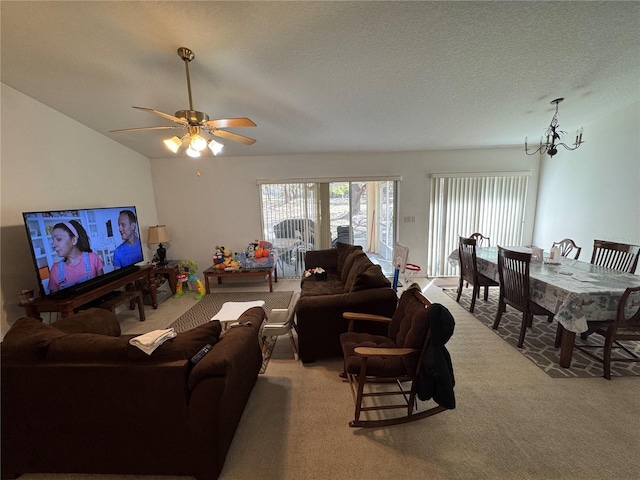 living area featuring light carpet, a textured ceiling, ceiling fan with notable chandelier, and vaulted ceiling