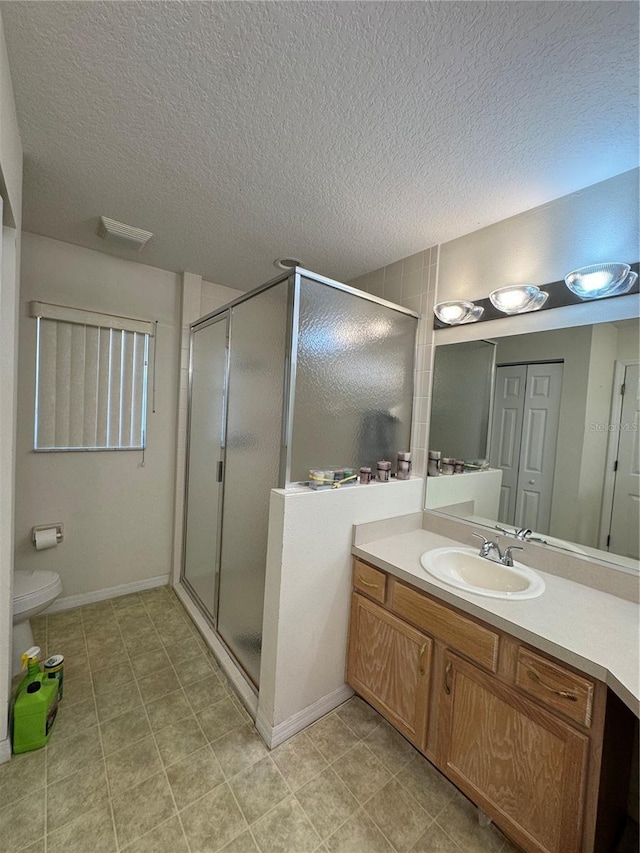 bathroom featuring vanity, a shower stall, and a textured ceiling