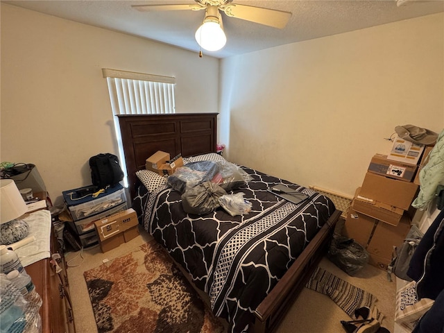 bedroom with a textured ceiling, ceiling fan, and carpet floors