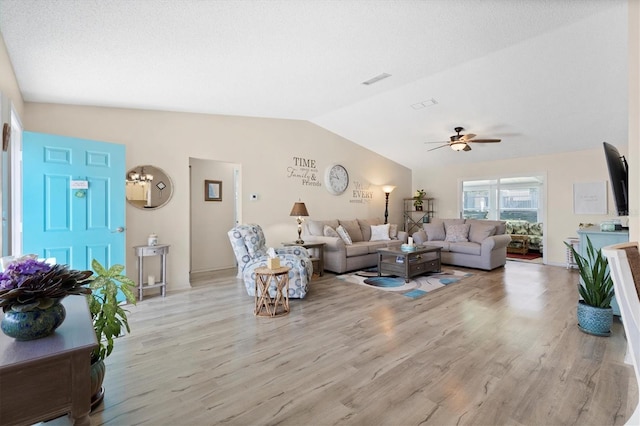 living area with light wood-style floors, visible vents, lofted ceiling, and a ceiling fan