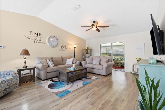 living area with visible vents, lofted ceiling, wood finished floors, and a ceiling fan