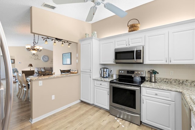 kitchen featuring visible vents, appliances with stainless steel finishes, white cabinets, and ceiling fan with notable chandelier